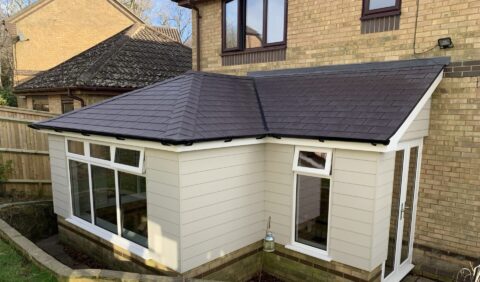 A house featuring a traditional roof and a sunroom, also known as a conservatory, enhancing its living space.