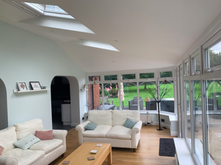 A bright conservatory featuring a glass roof and a spacious patio for outdoor relaxation.