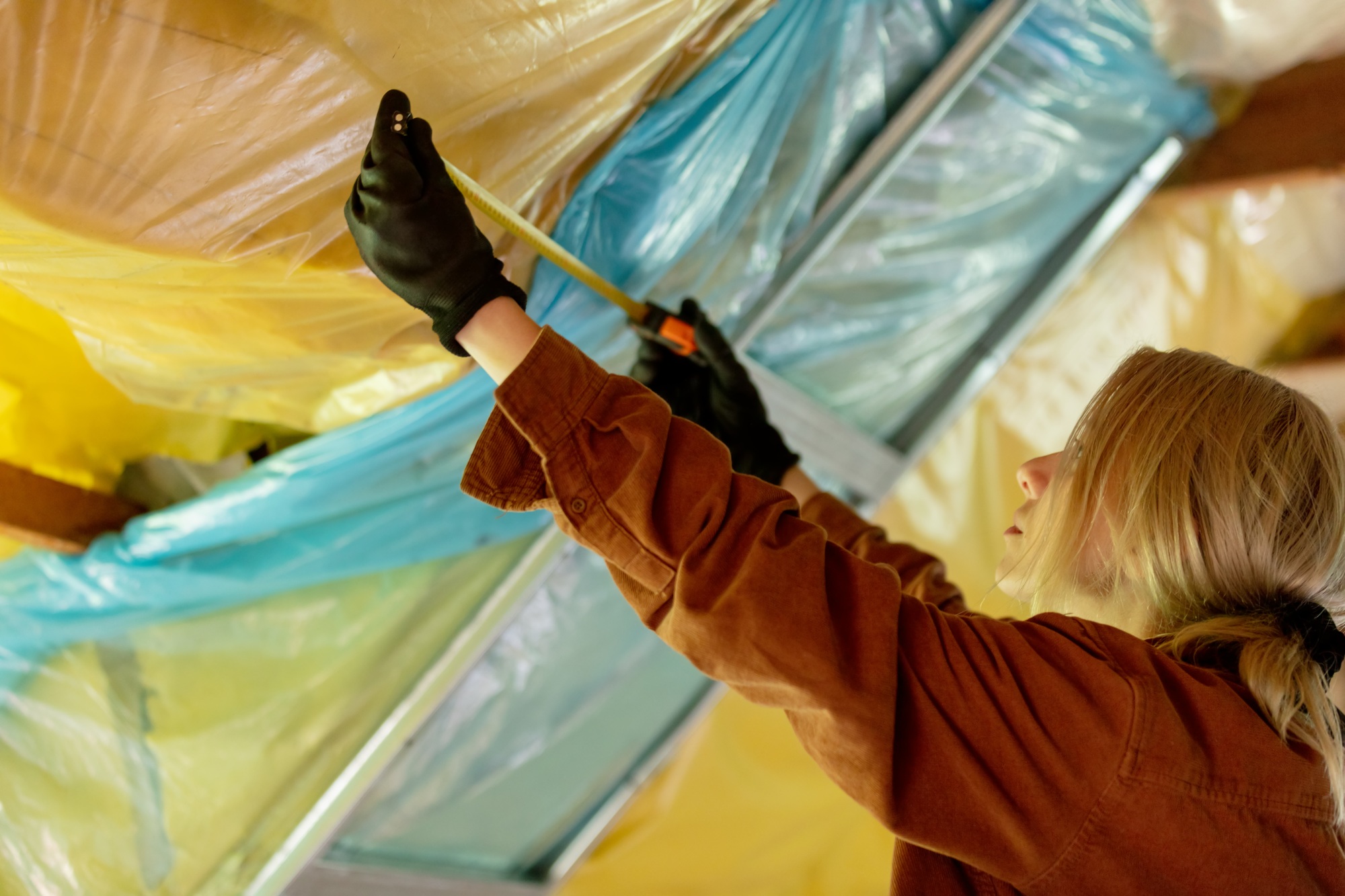 Woman with screwdriver fix roof in home